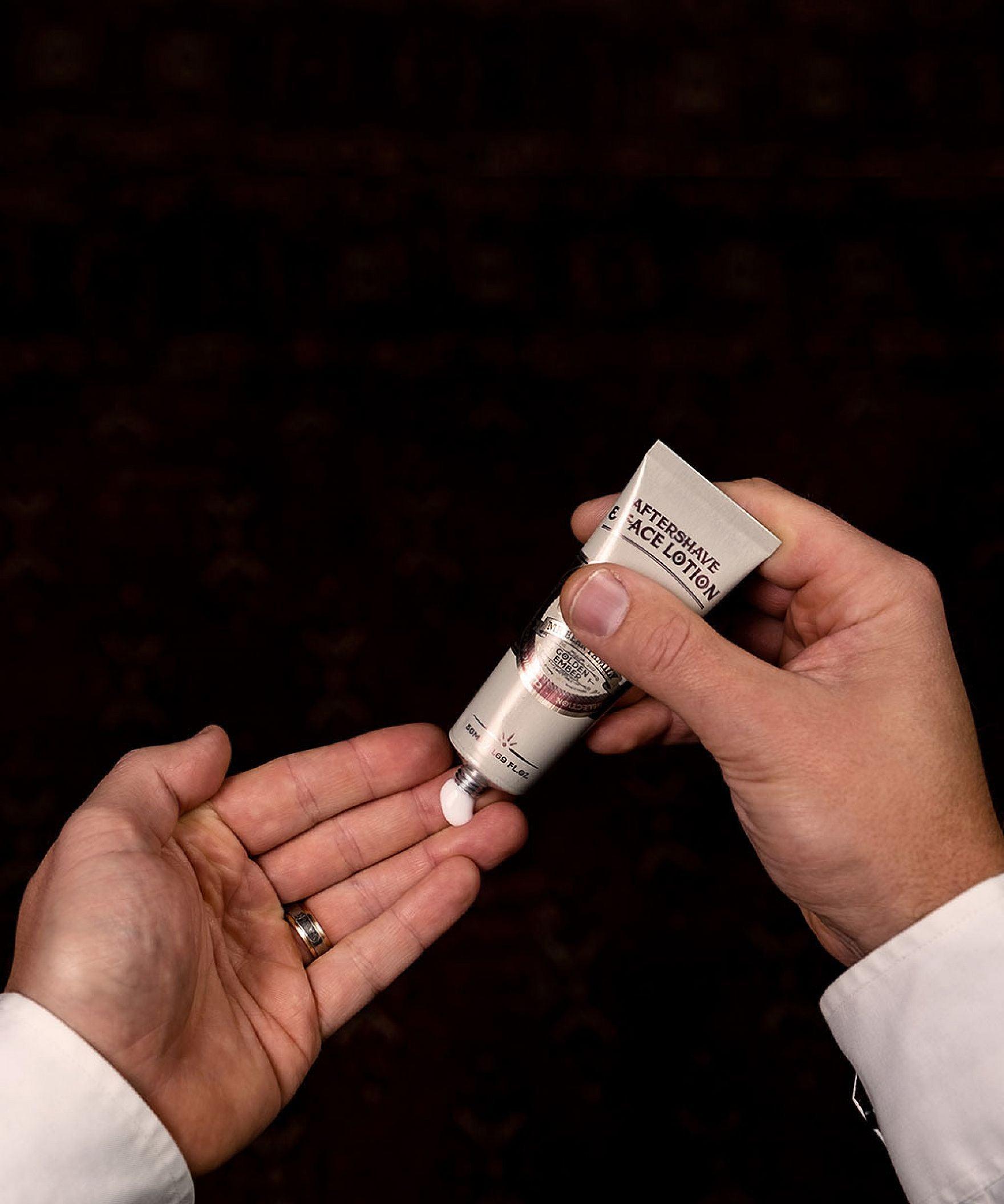 Man som häller aftershave i sin hand