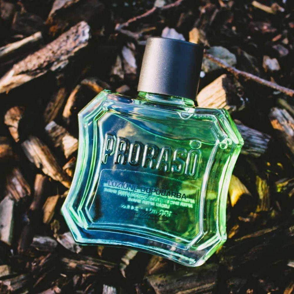 En flaska Proraso After Shave Lotion - Uppfriskande (grön) sittande på en trähög.