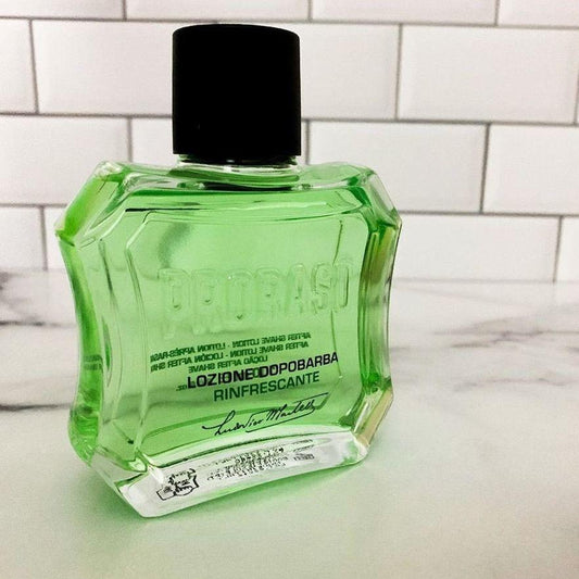 En flaska Proraso After Shave Lotion - Uppfriskande (grön) sittande på en disk.