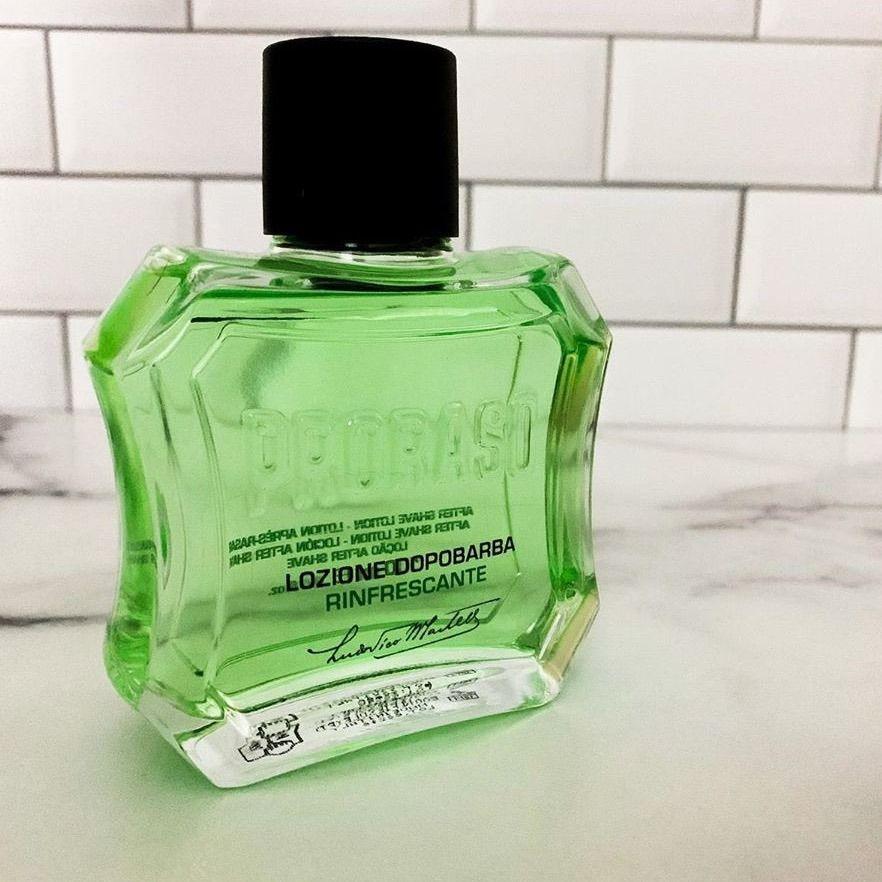 En flaska Proraso After Shave Lotion - Uppfriskande (grön) sittande på en disk.