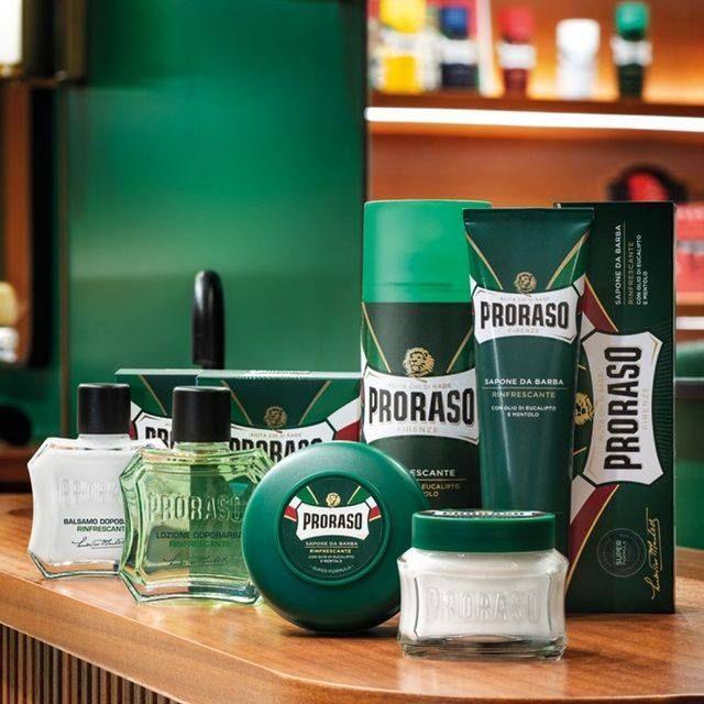 En samling prasadaprodukter på ett bord, inklusive eukalyptus och Proraso Rakkräm - Refreshing i tube (grön).