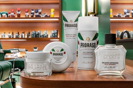En frisörsalong med olika produkter på bordet, bland annat Proraso Raktvål i skål - Citrus och grönt te och raknings tillbehör.