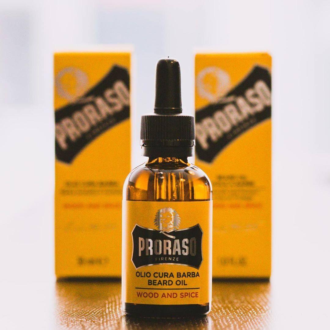 En flaska Proraso Skäggolja - Wood & Spice skäggolja på ett träbord.